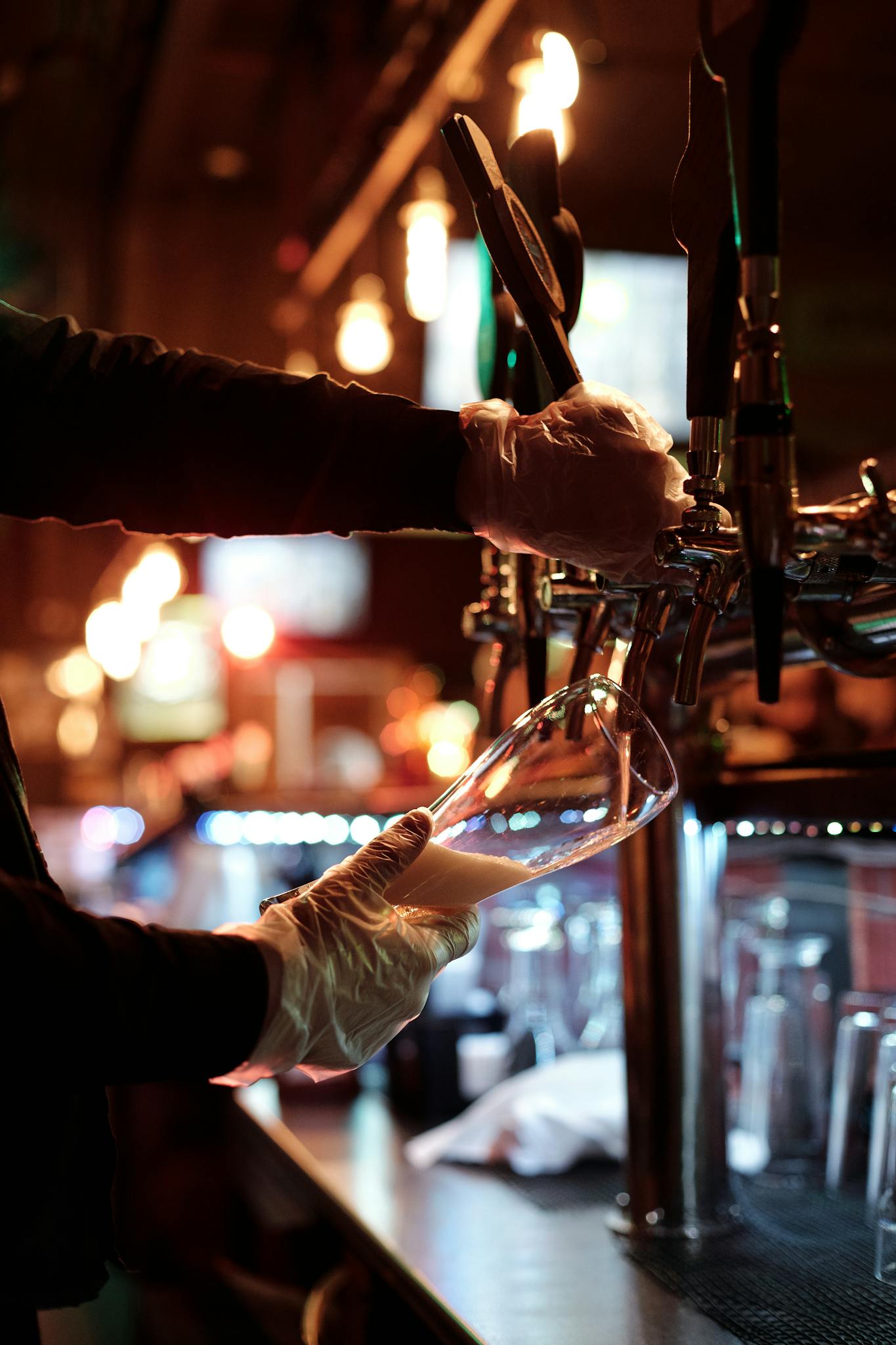 Bartender pours beer at a lively bar, creating a perfect evening ambiance.