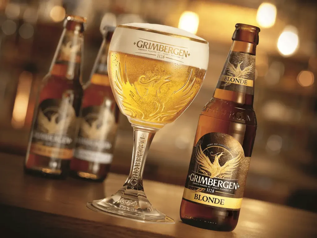 Grimbergen Blond servida en copa cáliz mostrando su color dorado brillante