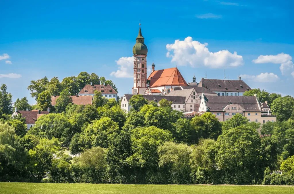 Vista panorámica de la Abadía de Andechs en Baviera, Alemania, rodeada de vegetación y con su icónica torre cebolla al fondo