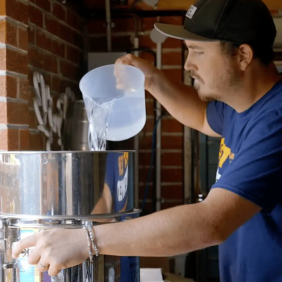 Lavado por lotes tradicional: se vierte el agua caliente manualmente tras el primer drenaje.