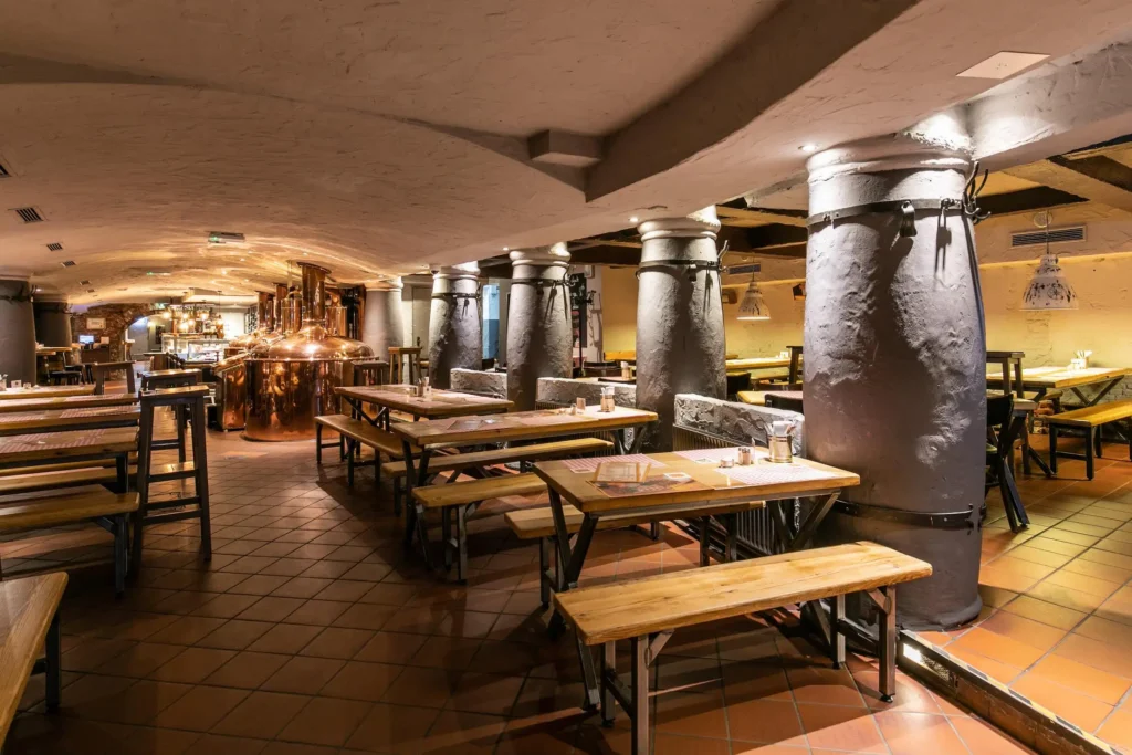 Sala principal con calderas de cobre y mesas comunales en Gröninger Privatbrauerei, Hamburgo.