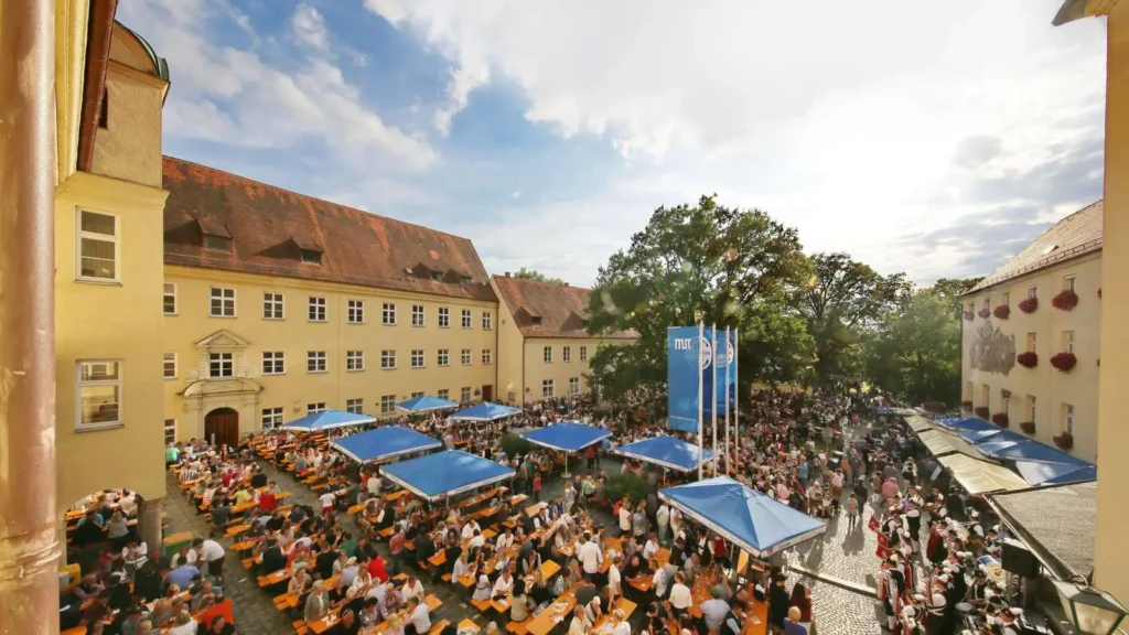 Celebración de la Bergfest en la cervecería Weihenstephan en Baviera, con mesas al aire libre y público festivo.