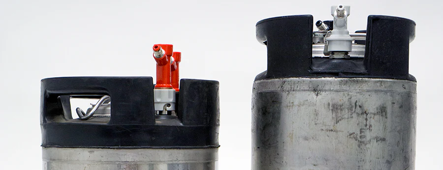 Comparativa entre barriles Cornelius Ball Lock (derecha) y Pin Lock (izquierda), diferenciados por sus conectores y tamaño. Fuente: Austin Homebrew Supply.