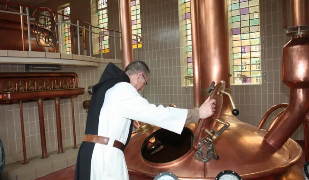 Monje trapense abriendo un tanque de cobre en la cervecería de Rochefort