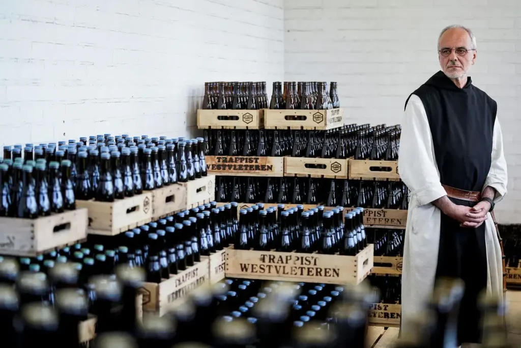 Monje trapense junto a cajas de cerveza Westvleteren en una bodega de la abadía de Sint-Sixtus