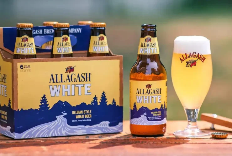 Allagash White servida en vaso oficial con pack de 6 botellas, la witbier belga americana de Portland