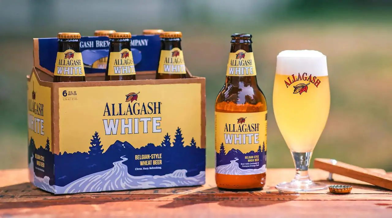 Allagash White servida en vaso oficial con pack de 6 botellas, la witbier belga americana de Portland
