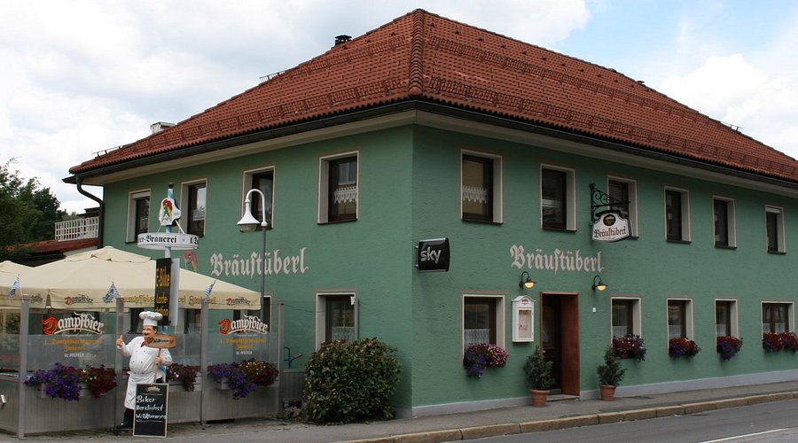 Cervecería histórica bávara en Zwiesel, Bosque Bávaro, edificio tradicional verde con tejado rojo y terraza Dampfbier